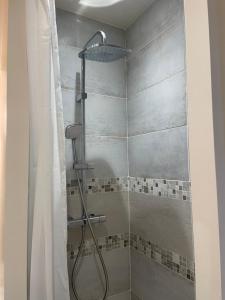 a shower with a shower curtain in a bathroom at Chez Sophie in Orléans
