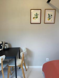 a dining room with a table and two pictures on the wall at Chez Sophie in Orléans