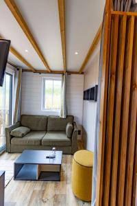 a living room with a couch and a table at Les Chalets du Lac - Amnéville Cité des Loisirs Galaxie in Amnéville