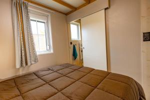 a bedroom with a large bed with a window at Les Chalets du Lac - Amnéville Cité des Loisirs Galaxie in Amnéville