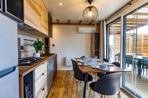 a kitchen and dining room with a table and chairs at Les Chalets du Lac - Amnéville Cité des Loisirs Galaxie in Amnéville
