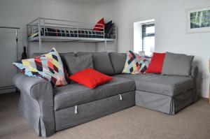 a gray couch with colorful pillows in a living room at Pier Cottage at Kames in Kames