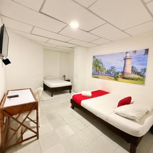 a bedroom with a bed and a desk and a table at Hotel Toledo FL in Cartagena de Indias