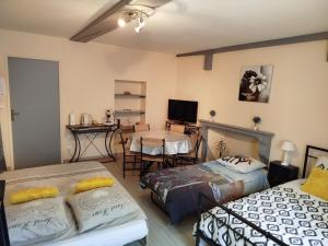 a living room with two beds and a table at L'Epinette in Torchefelon