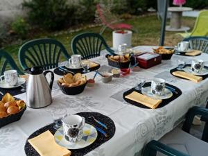 a table with cups and plates of food on it at L'Epinette in Torchefelon