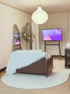 a living room with a bed and a flat screen tv at Dazzlday in Seoul