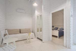 a white bedroom with a bed and a table and a chair at Casa Blanca Olimp in Olimp