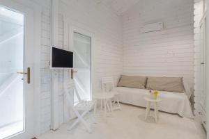 a room with a bed and a table and a tv at Casa Blanca Olimp in Olimp