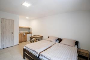 a bedroom with a bed and a table and a kitchen at Ubytování Smějsík in Blatnice