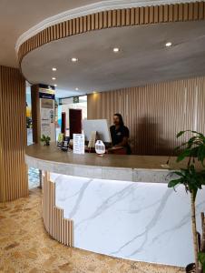 a man sitting at a reception desk in a lobby at Hotel Toledo FL in Cartagena de Indias +20 photos
