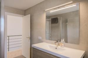 a bathroom with a white sink and a mirror at Casa con jardín en Besalú, ideal para familias in Besalú +33 photos