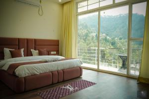 a bedroom with a large bed and a large window at The Oaks - Scenic Couple Retreat in Kasauli with Private Balcony Views in Kasauli