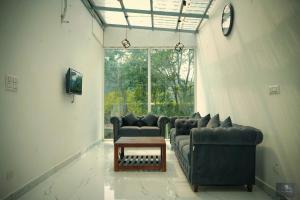 a living room with couches and a table and a window at The Oaks - Scenic Couple Retreat in Kasauli with Private Balcony Views in Kasauli