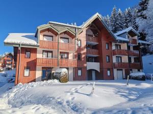 a large apartment building in the snow with snow at Charmant studio montagne - vue dégagée - pied des pistes in Mijoux