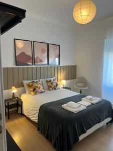 a bedroom with a large bed with towels on it at Alvalade II Airport Guest House in Lisbon