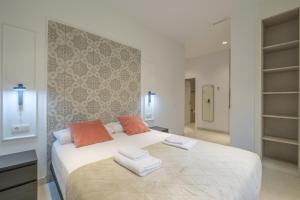 a bedroom with a large white bed with towels on it at Chic & Comfortable Apartment, Private Terrace in Valencia