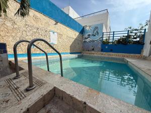 a swimming pool in a building with blue walls at Hotel Toledo FL in Cartagena de Indias