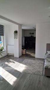an empty living room with white walls and wooden floors at Paul's Houses 2 in Ocna-Mureşului