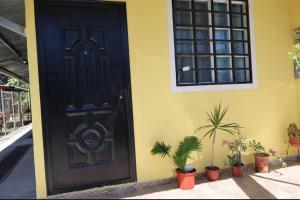a black door on the side of a house with plants at Hospedaje Ofe,S #3 in Santiago +4 photos