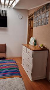 a bedroom with a bed and a dresser with a drawer at Hatuchay Inka Apart Hotel in Cajamarca