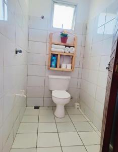 a small bathroom with a toilet and a window at Adventure studio apartment in Mtwapa