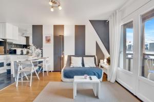 a bedroom with a blue bed and a kitchen at L'Échappée Belle de Houlgate 2 personnes in Houlgate