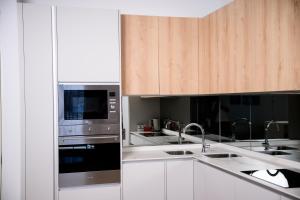 a kitchen with stainless steel appliances and wooden cabinets at SoftStay Ellipse Luxury Apartment in Midrand