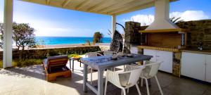 a kitchen with a table and chairs and the ocean at KYMO Private Seafront Residence in Koutsourás