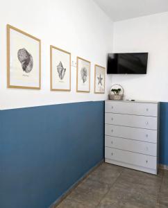 a room with four pictures on the wall and a dresser at KYMO Private Seafront Residence in Koutsourás