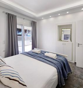 a bedroom with a large bed with two towels on it at KYMO Private Seafront Residence in Koutsourás