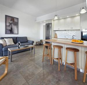 a kitchen and living room with a couch and a table at KYMO Private Seafront Residence in Koutsourás