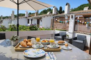 a table with a breakfast of bread and croissants at Casa Tossa – Piscina, Vistas Mar y A/C (6 pax) in Tossa de Mar