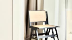 a wooden chair sitting in front of a window at Bayab Charming Rooms - Corso Garibaldi in Benevento