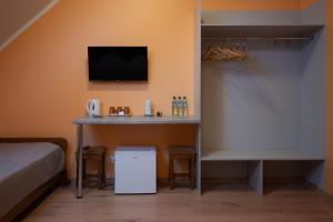 a room with a table with a tv and a bed at Kurna Mõis in Kurna