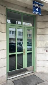 a green door on a building with a sign above it at Palais Petrus in Vienna