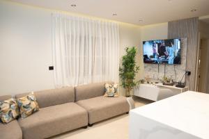 a living room with a couch and a flat screen tv at Star Villa Boca Chica in Boca Chica