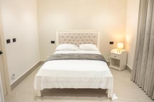 a white bedroom with a large bed and a lamp at Star Villa Boca Chica in Boca Chica +14 photos