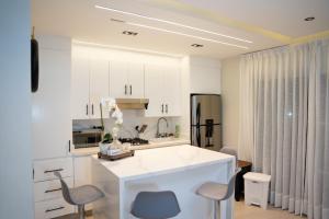 a kitchen with white cabinets and a white counter top at Star Villa Boca Chica in Boca Chica