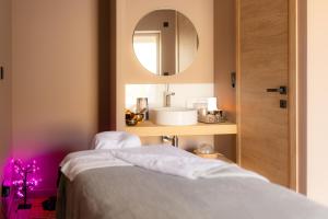 a room with a bed and a mirror and a sink at CASA ioio in Jaunay-Clan