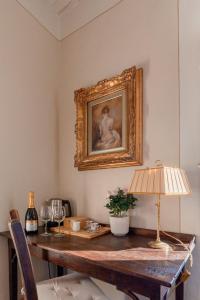 a table with a lamp and a painting on the wall at La Dimora di Corte in Lucca