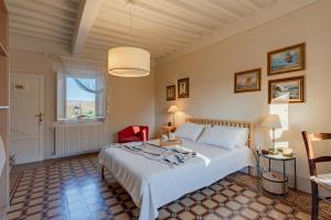 a bedroom with a large white bed and a window at La Dimora di Corte in Lucca
