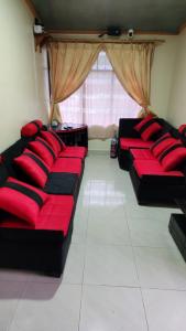 a living room with black and red couches and a window at Villa Tungurahua in Huamboya
