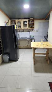 a kitchen with a refrigerator and a table in it at Villa Tungurahua in Huamboya +1 photo