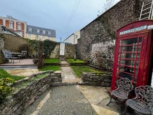 eine rote Telefonzelle neben einer Backsteinmauer in der Unterkunft The Innbetween in Pembroke Dock
