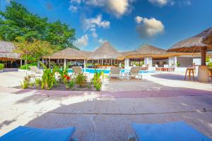 a resort with a pool and chairs and straw umbrellas at Keur Saloum Resort in Toubakouta
