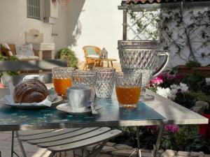 a table with glasses and a plate of food on it at Le Jardin Fleuri in Castelluccio Valmaggiore