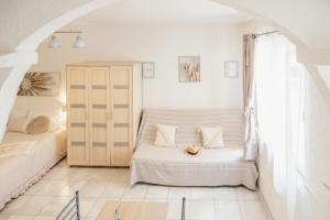 a white room with two beds and a couch at Studio confort, chic & spacieux Plage de Juan les pins & central in Juan-les-Pins
