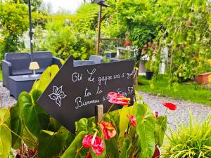 a sign in a garden with flowers at La Kaz 57 - Maison avec jacuzzi et sauna - La Réunion in La Plaine des Palmistes +36 photos