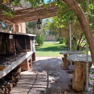 a picnic table and bench under a wooden pergola at Casona El Olivo in Villa Krause