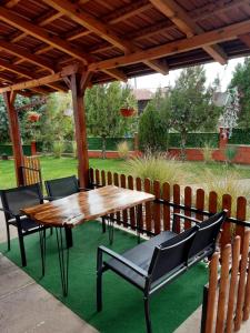 a wooden table and chairs under a wooden pergola at Villa Elena in Čiflik